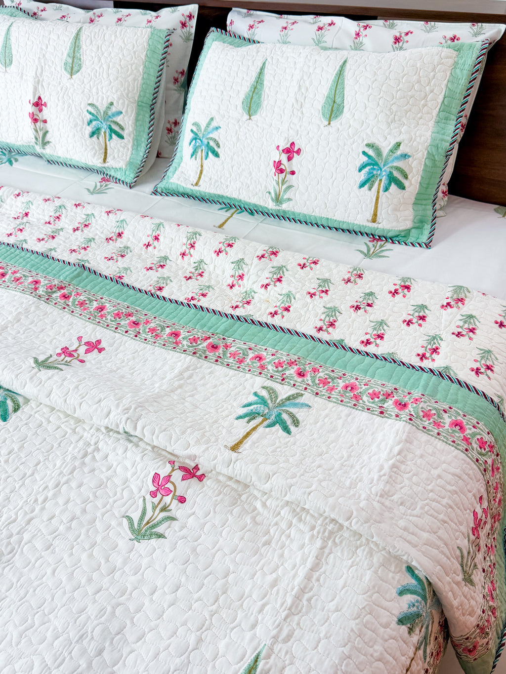 Palm and Pink Floral quilted bedcover showing its pink floral border.