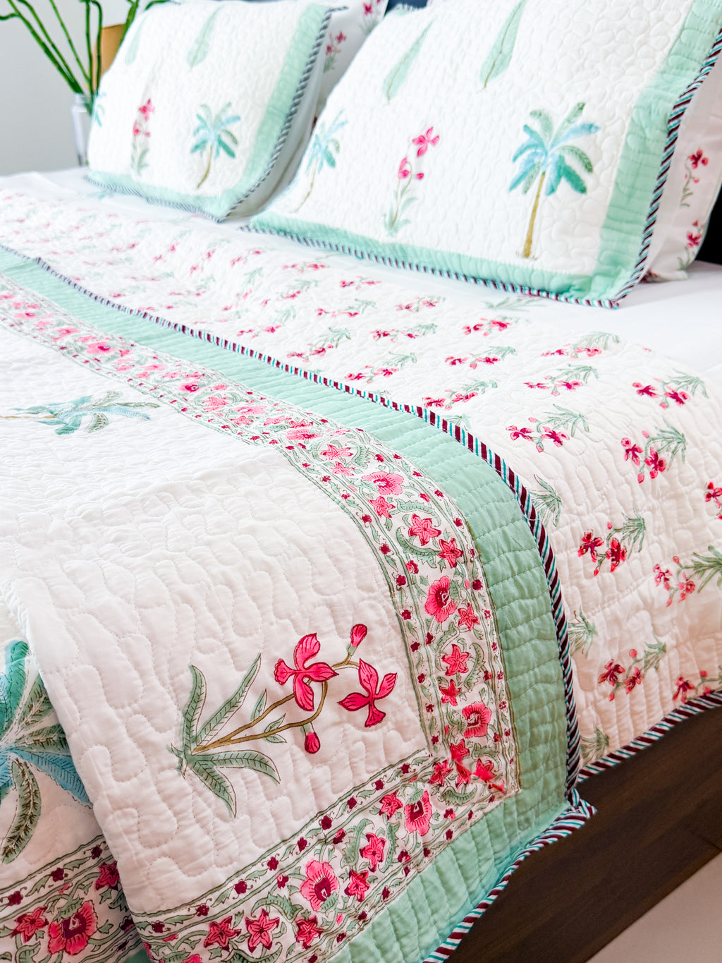 Palm and Pink Floral quilted bedcover detail with mint border.