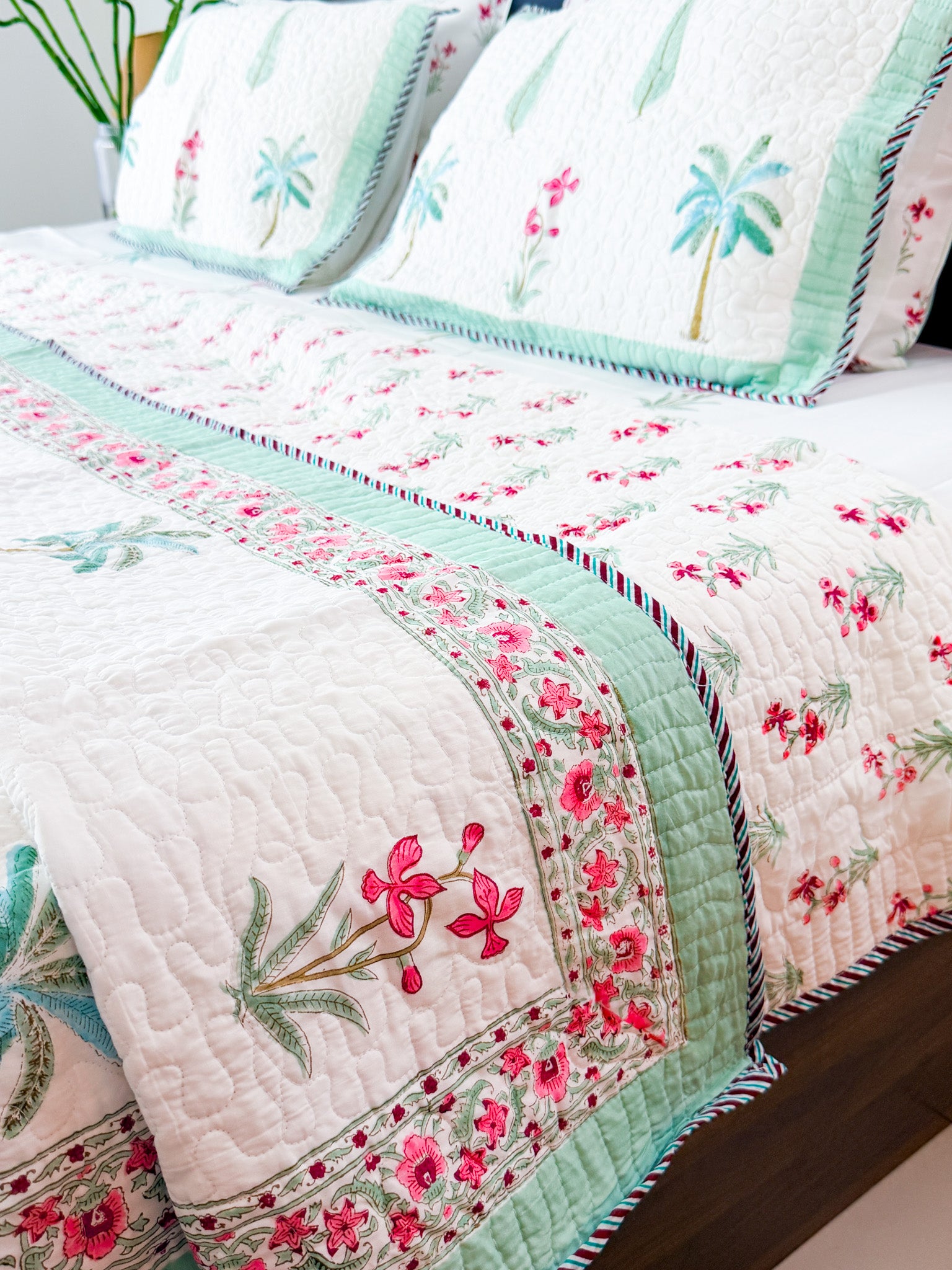 Palm and Pink Floral quilted bedcover detail with mint border.