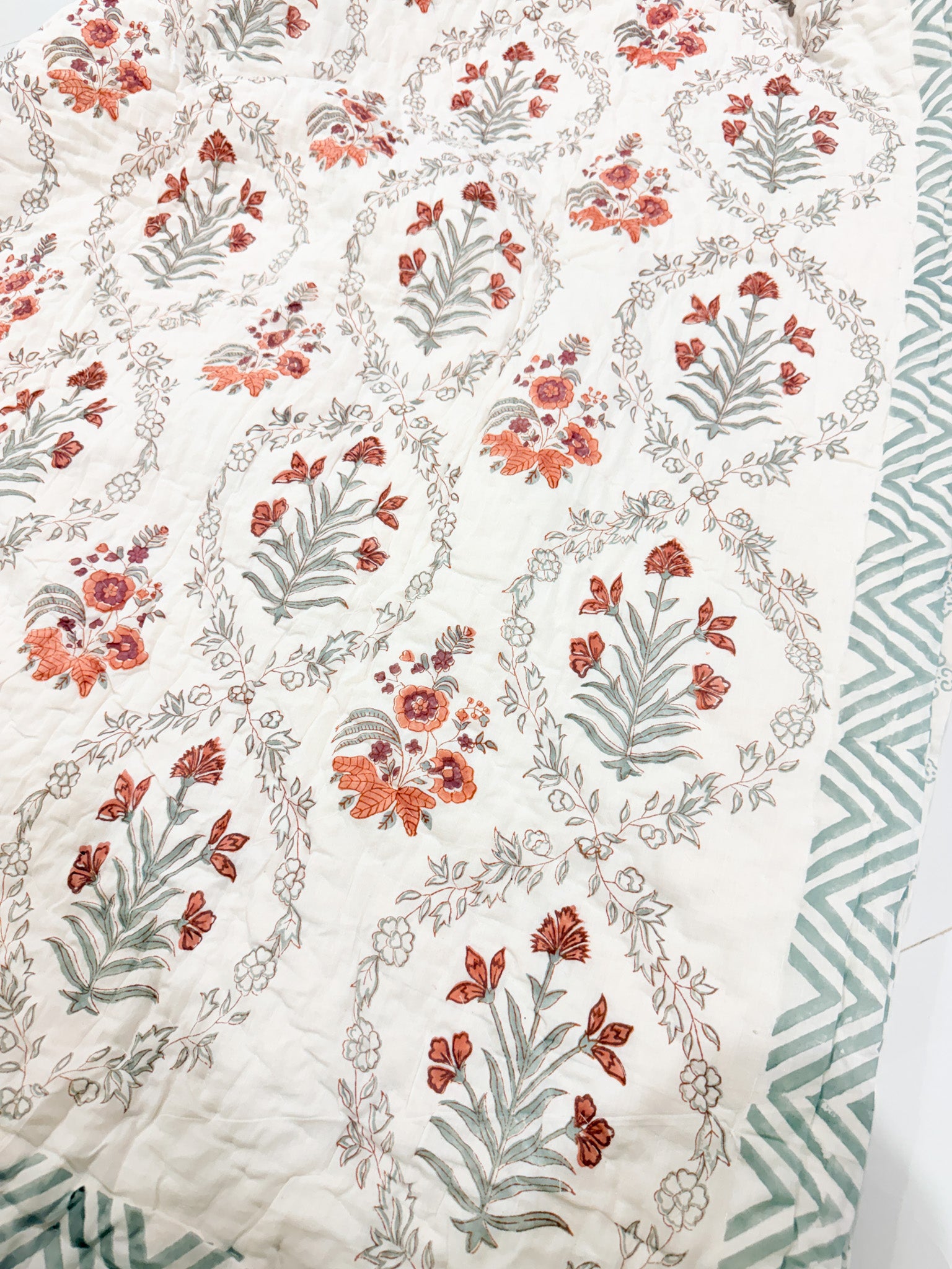 Floral side detail of ORA Living Sage and Rust Floral Handblock Reversible Pure Mulmul Cotton Quilt