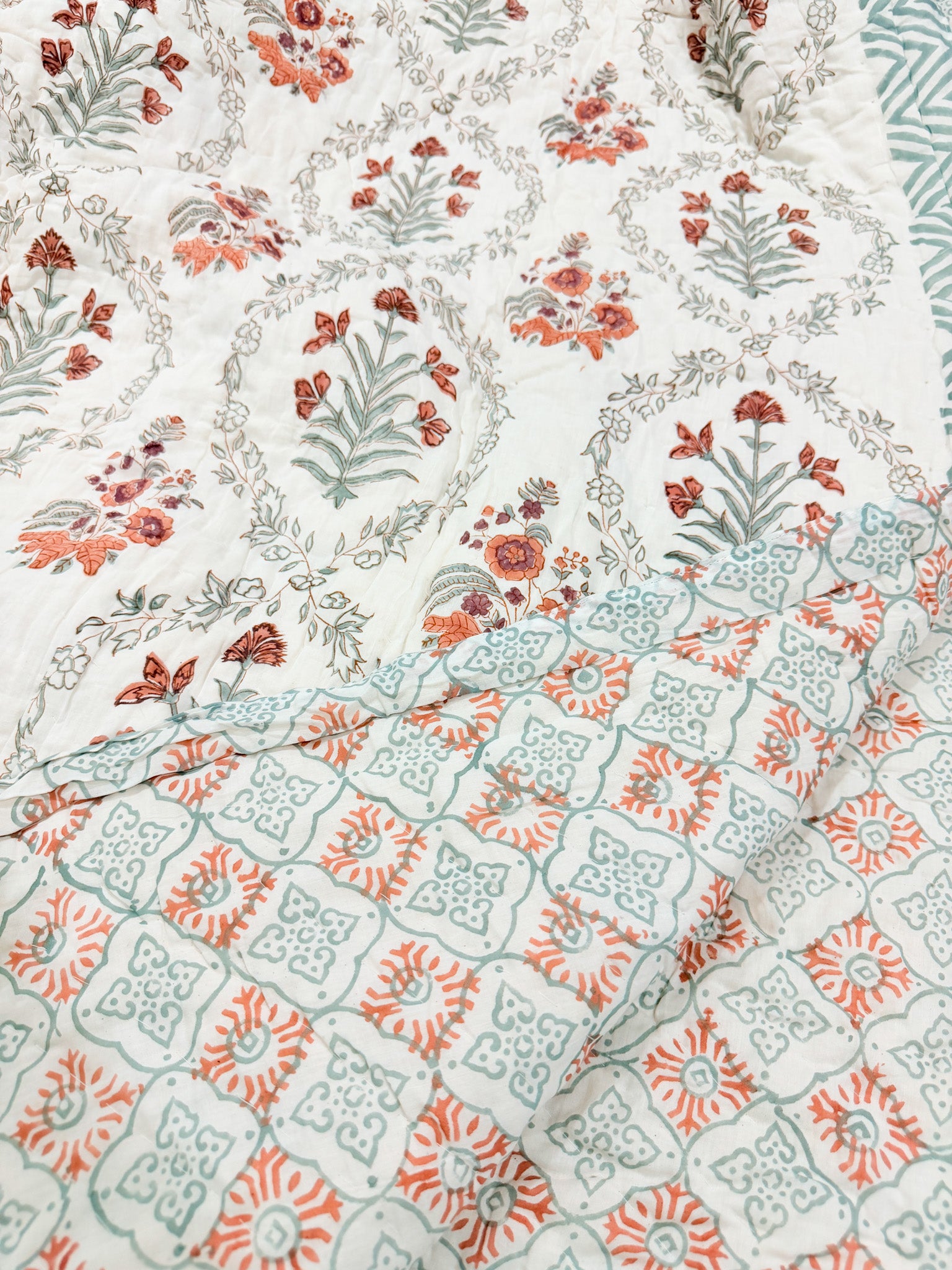 Reversible floral and geometric print detail of ORA Living Sage and Rust Floral Handblock Reversible Pure Mulmul Cotton Quilt