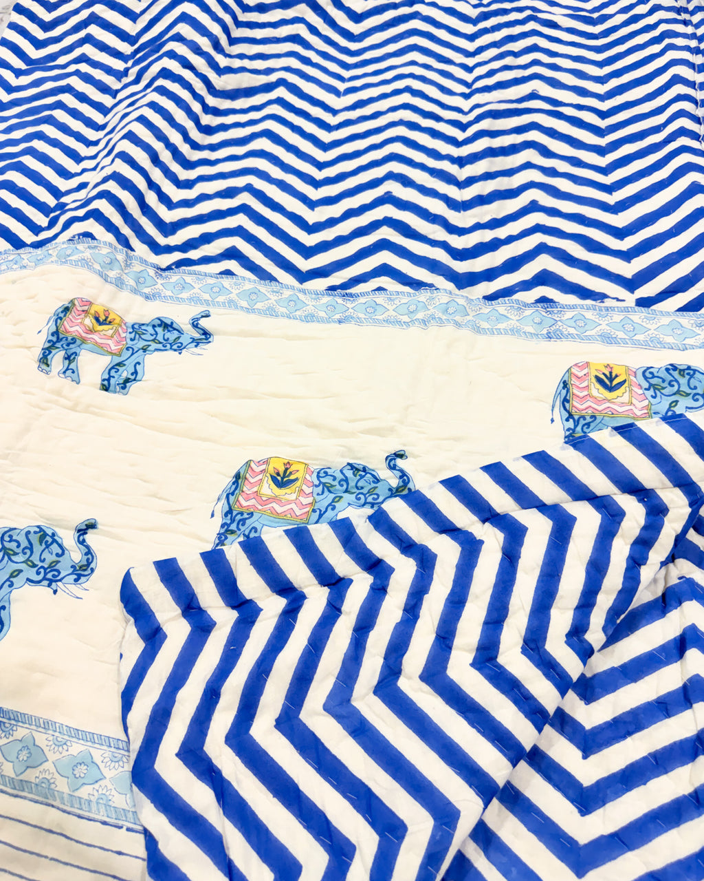 Close-up of the blue chevron and elephant print on ORA Living's reversible Pure Mulmul Cotton Quilt