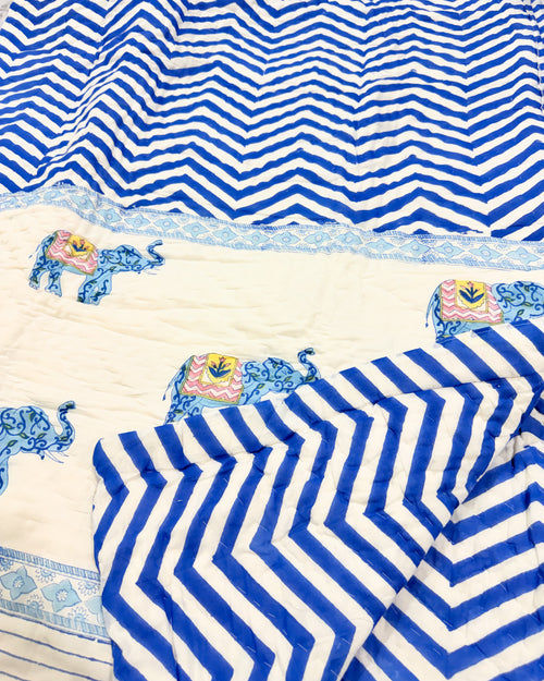 Close-up of the blue chevron and elephant print on ORA Living's reversible Pure Mulmul Cotton Quilt
