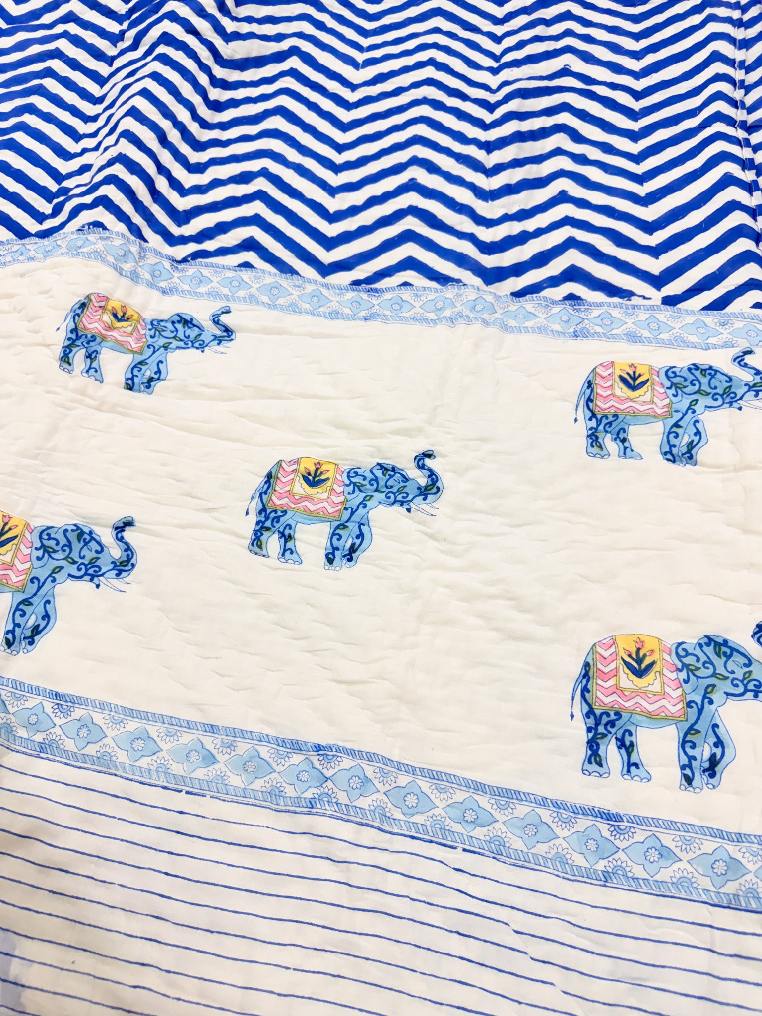 Detail of the elephant motif and blue chevron border on ORA Living's reversible Pure Mulmul Cotton Quilt