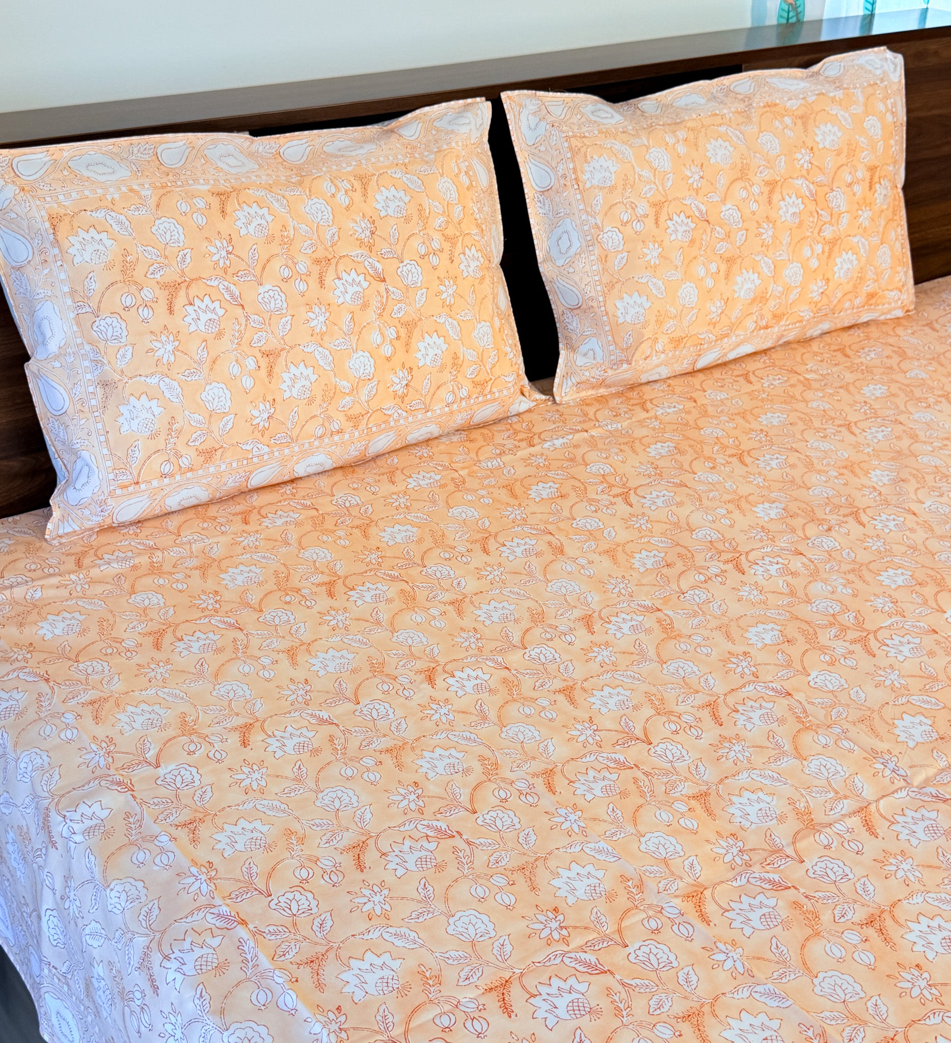 ORA Living Orange White Floral Handblock Premium Cotton Bedsheet Set styled on a bed