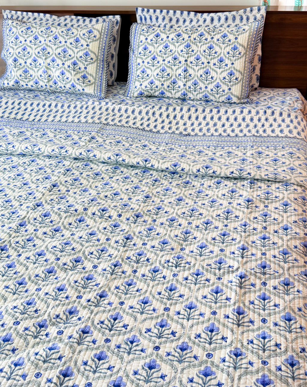 Blue Floral Butta quilted bedcover styled bed view.