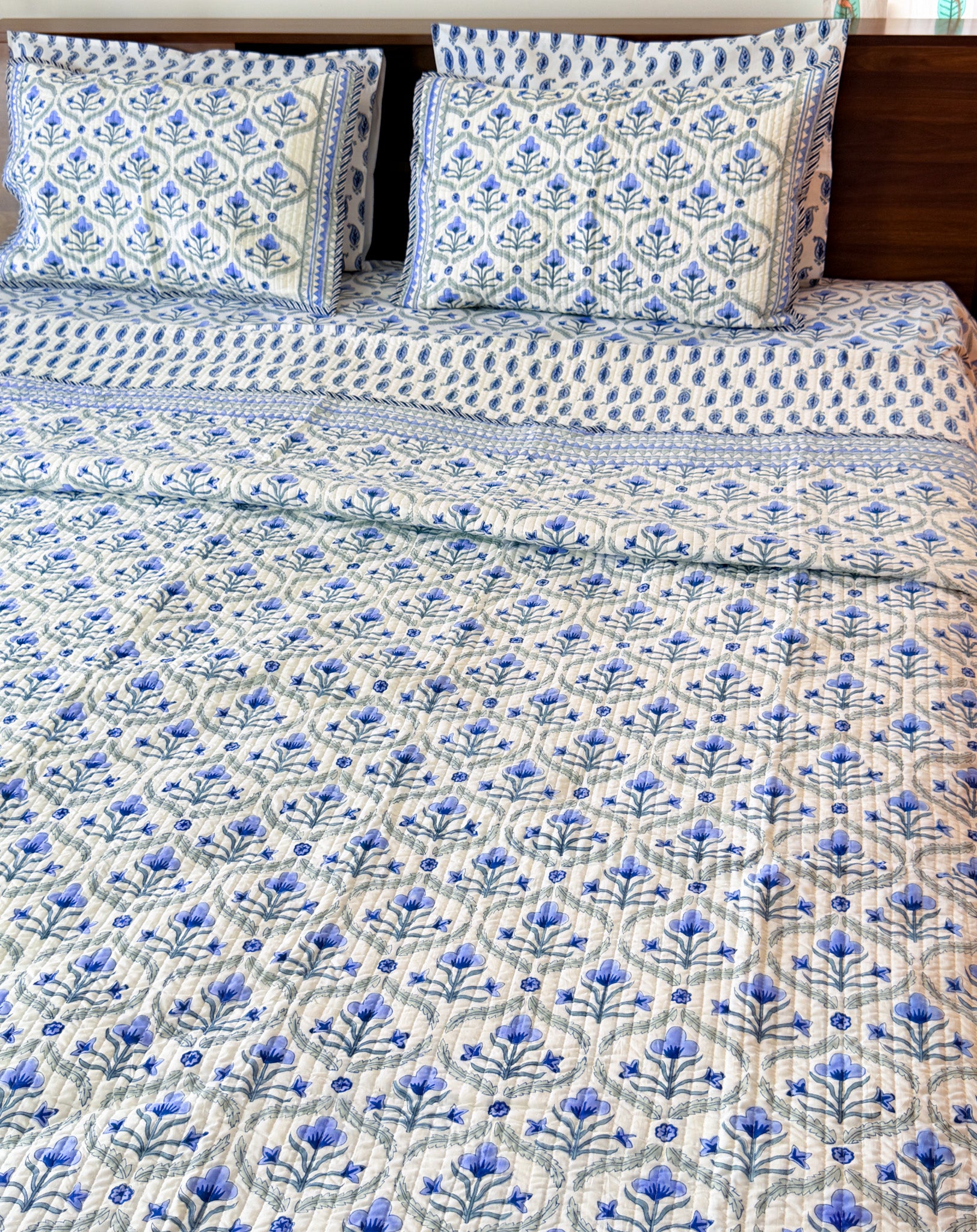 Blue Floral Butta quilted bedcover styled bed view.